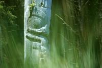 Totem pole with out-of-focus green grass