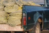 Black truck piled high with rope