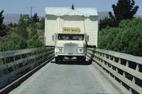 Truck moving a wide load across a bridge
