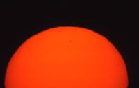 Red setting sun, long lens