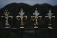 Sheep and Abbey : painted wrought-iron fence with fleur-de-lis