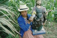 Woman displaying Christ figure, cornfield