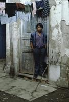 A man standing in a doorway, below a line of laundry