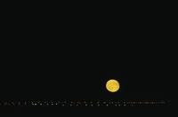 Full moon over lights of Saskatoon