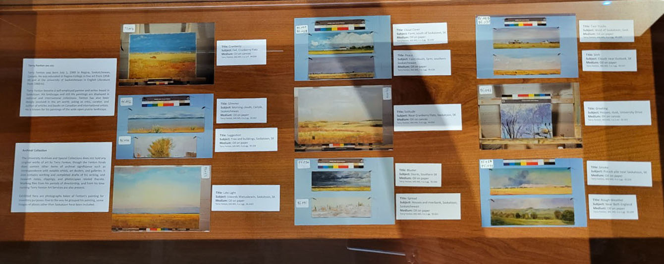 Photographs of paintings laid out on a display case.
