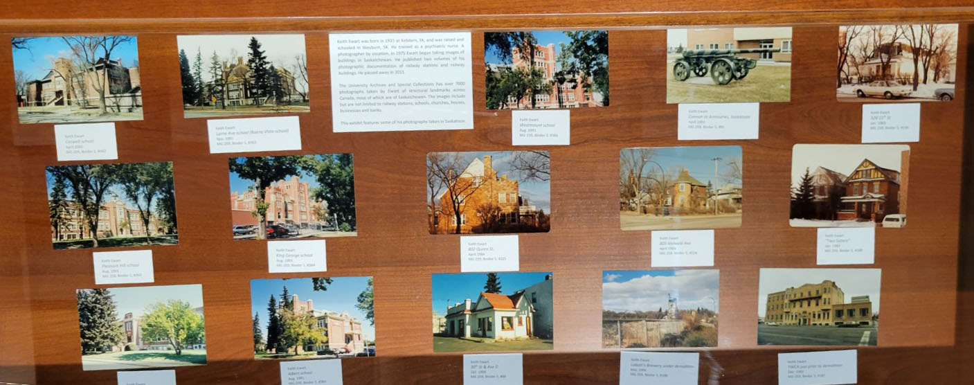 A selection of photographes of buildings laid out on a display case.